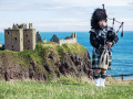 Un joueur de cornemuse Ecossais près du château de Dunnottar