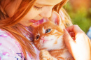 Une petite fille avec un chaton roux