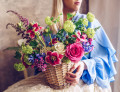 Jeune femme avec un panier de fleurs