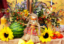 Photo du décor d’automne et d’une poupée nationale faite à la main avec des feuilles, des pastèques, des fleurs et une récolte