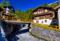 Rivière et chalets dans un village suisse des Alpes