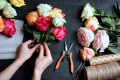 Un fleuriste arrange un bouquet de roses