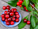 Cerises sur une assiette bleue sur une table dans le jardin